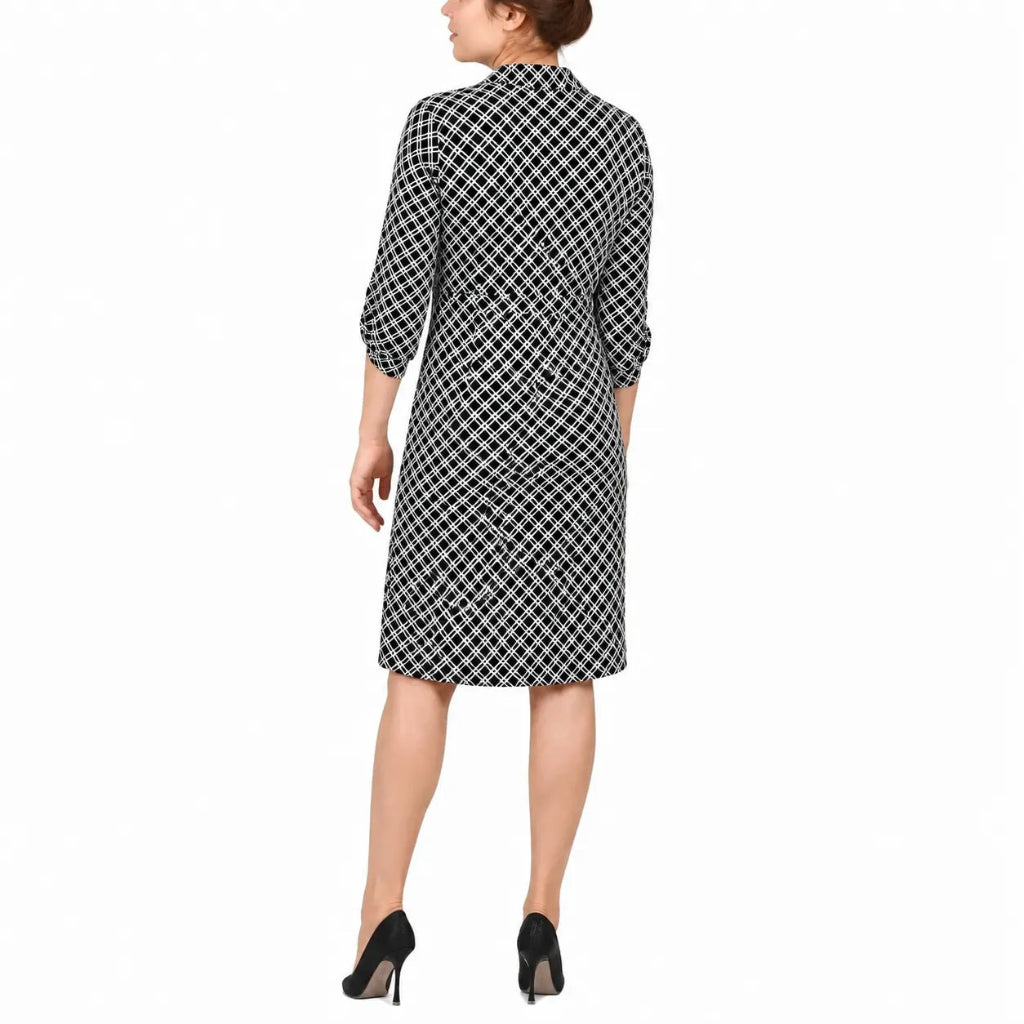A woman shown from the back wearing a black and white checkered shirt dress with three-quarter sleeves and black high heels, set against a plain white background.