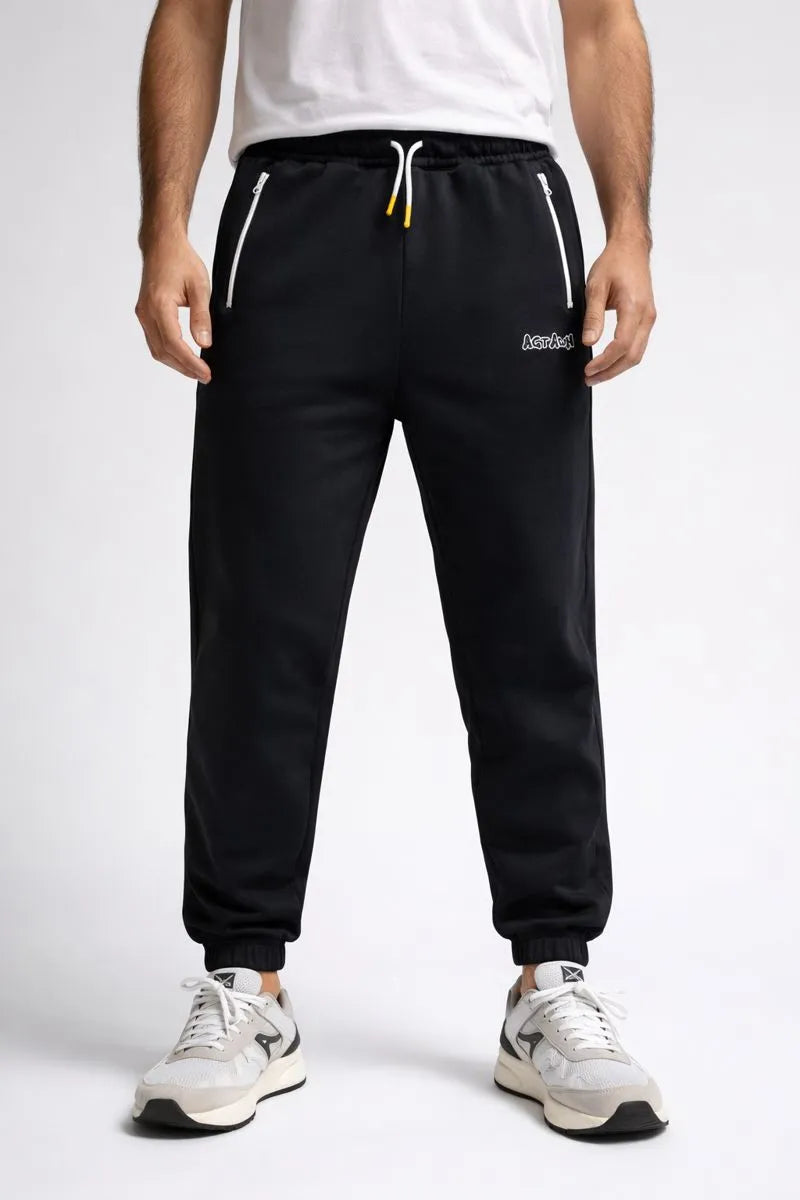 Person wearing black Reebok sweatpants on a white background