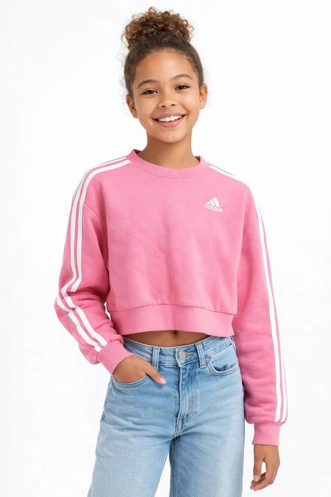 Girl wearing a pink Adidas sweatshirt with white stripes on a white background