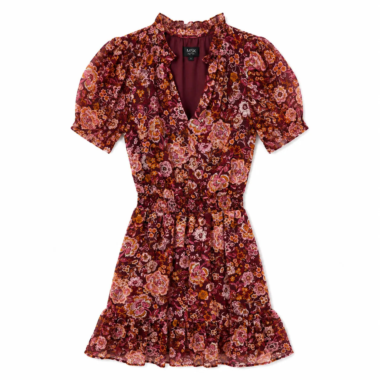 A short-sleeve floral mini dress by Mara Johnson, featuring a deep V-neckline, smocked waist, and ruffled hem in a dense rose, burgundy, and orange floral pattern.