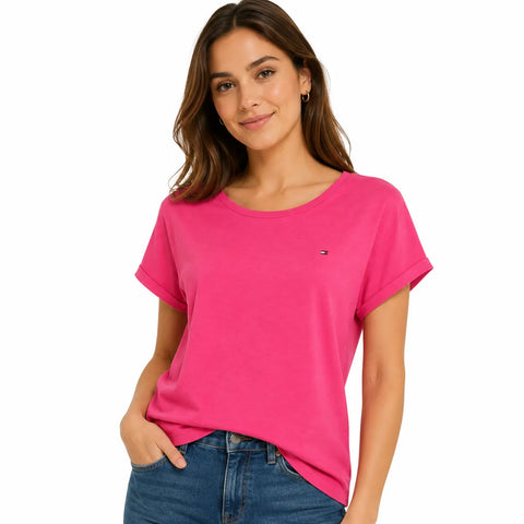 Woman wearing a bright pink t-shirt with a small logo on a white background