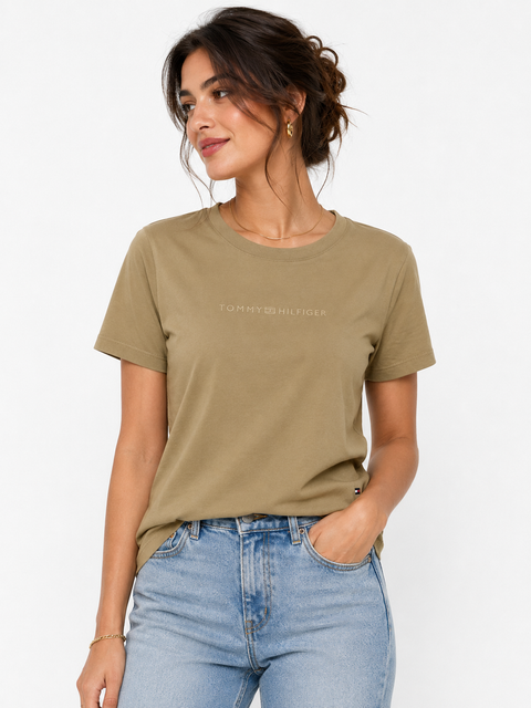 Woman wearing a green t-shirt and blue jeans on a white background