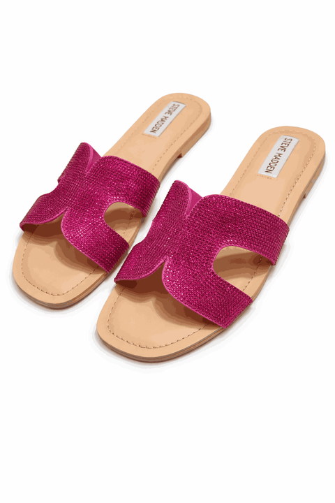 Pair of pink sandals with beige soles on a white background