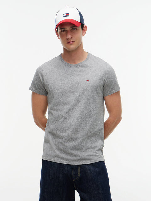 Man wearing a gray t-shirt and a cap with a visible brand logo on a white background