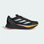 Black Adidas running shoe with white stripes on a light gray background