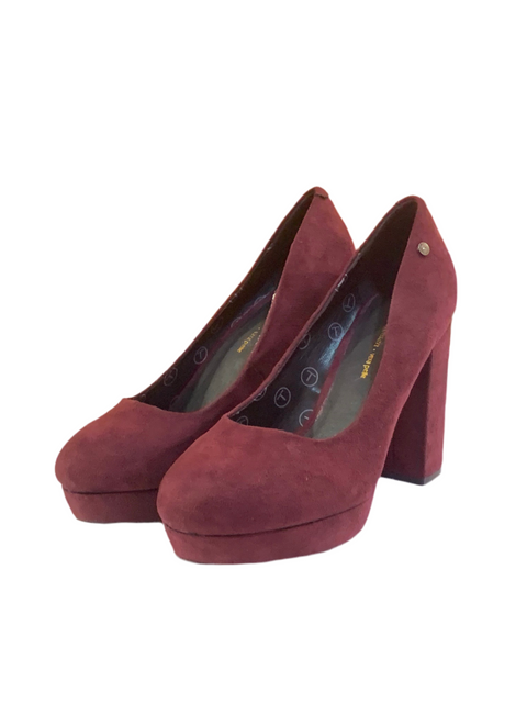 Pair of red high-heeled shoes on a white background
