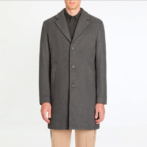 Man wearing a gray overcoat on a white background