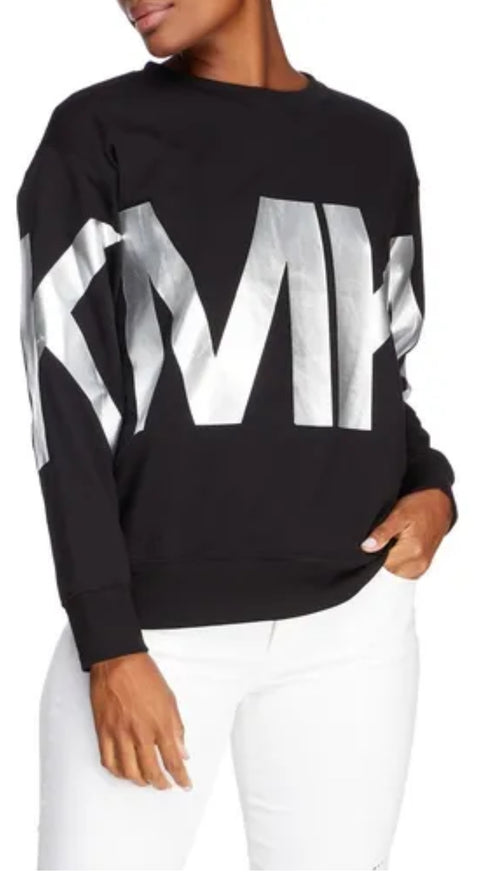 Black sweater with large white text worn by a person on a white background