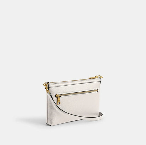 White handbag with gold accents on a light gray background