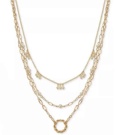 Layered gold necklaces with various links on a white background