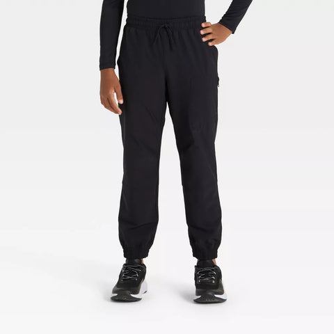 Person wearing black jogger pants on a white background
