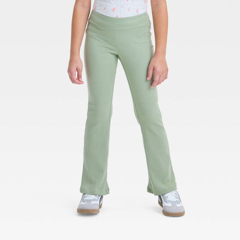 Person wearing light green ribbed pants on a white background