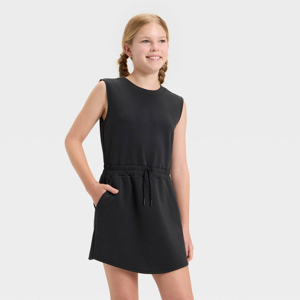 Young girl wearing a black sleeveless dress on a white background