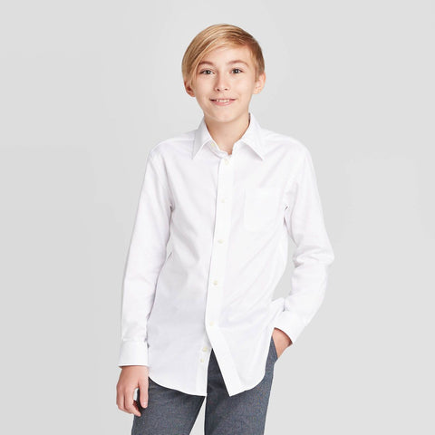 Young boy wearing a white dress shirt against a gray background