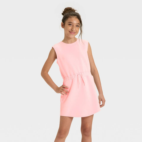 Young girl wearing a pink dress on a light gray background