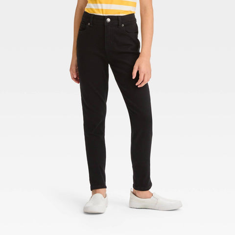Person wearing black jeans and a yellow top on a white background