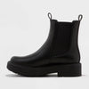Black Chelsea boot on a light gray background