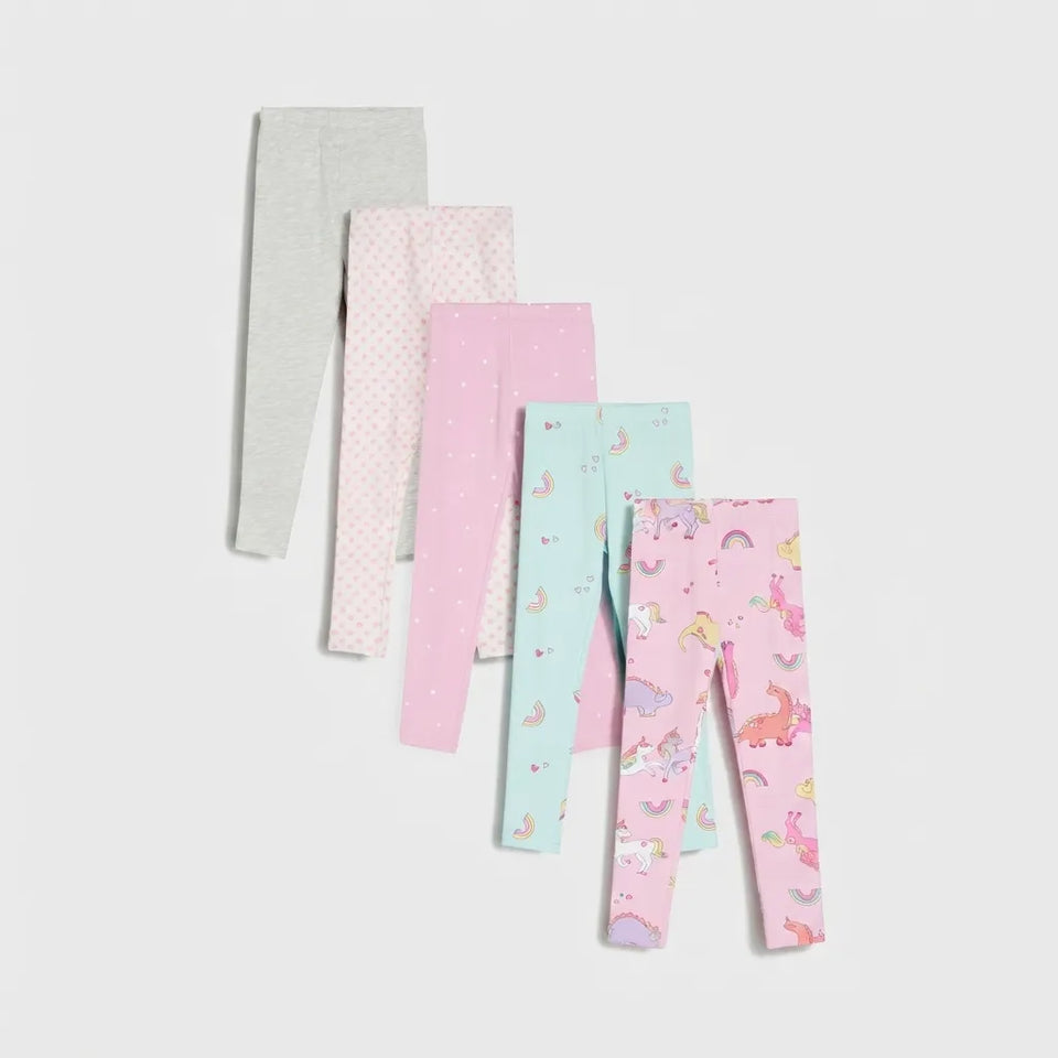 Five pairs of children's leggings in pastel colors, arranged in a fan shape on a light gray background. The leggings feature various patterns including solid gray, white polka dots, solid pink, light blue with small motifs, and a pink unicorn print.