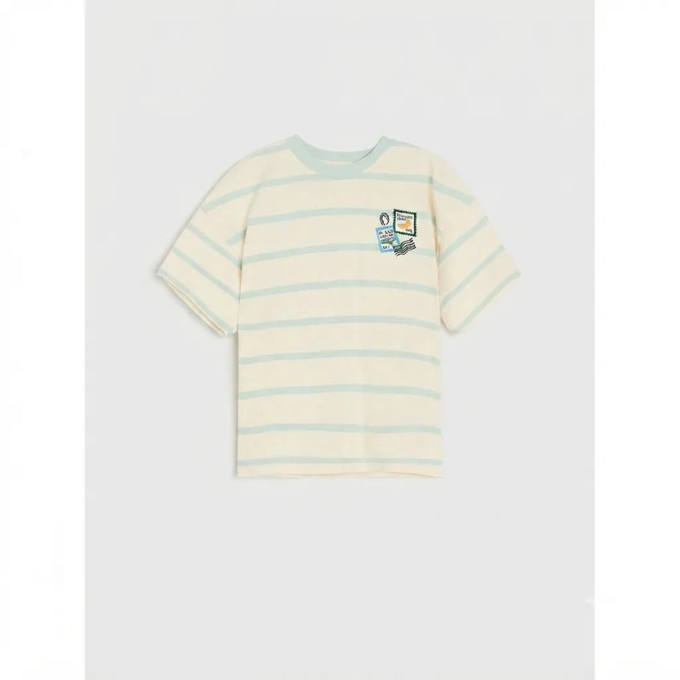 A short-sleeve crewneck t-shirt with horizontal light blue stripes on a cream base, featuring a small graphic print on the left chest, displayed against a light gray background.