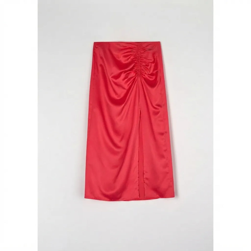 A bright red satin midi skirt with a gathered ruched waist and a front slit, laid flat against a light gray background.
