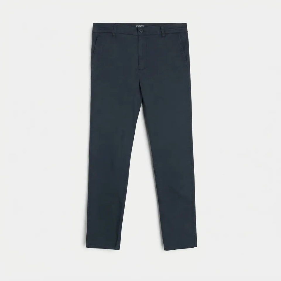 A pair of dark slate blue slim-fit trousers laid flat against a light gray background.