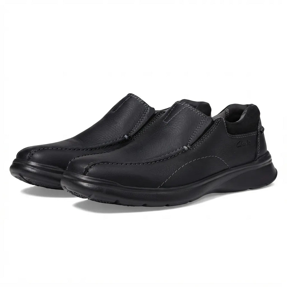 Black soccer cleats with brown accents on a white background