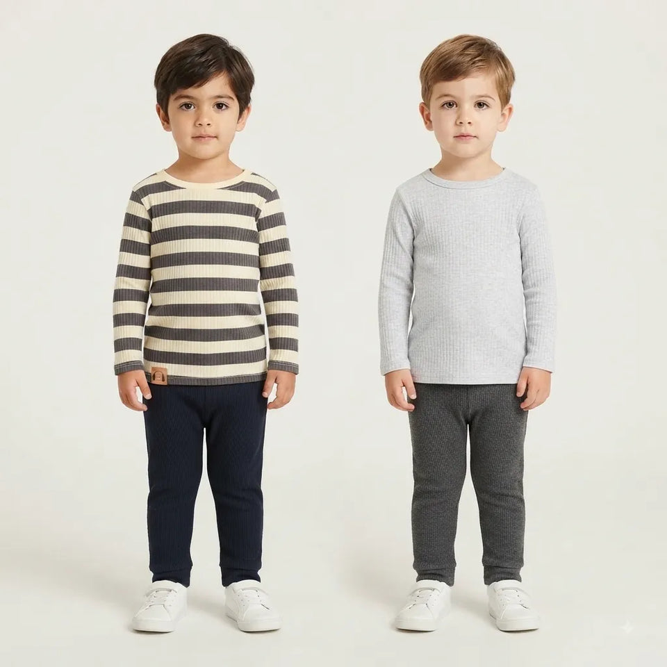 Two young boys modeling long-sleeve children's shirts. The boy on the left wears a cream and dark gray striped shirt with navy pants, and the boy on the right wears a light gray ribbed shirt with dark gray pants.