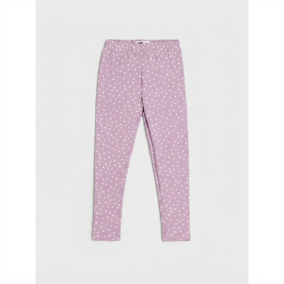 A pair of children's leggings in a dusty lavender-pink color, featuring a white polka-dot pattern, laid flat against a light gray background.