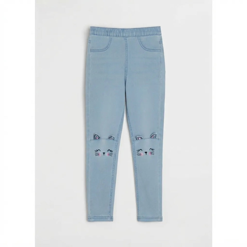 Light blue denim leggings with embroidered cat face details on the lower legs, displayed flat against a light gray background.