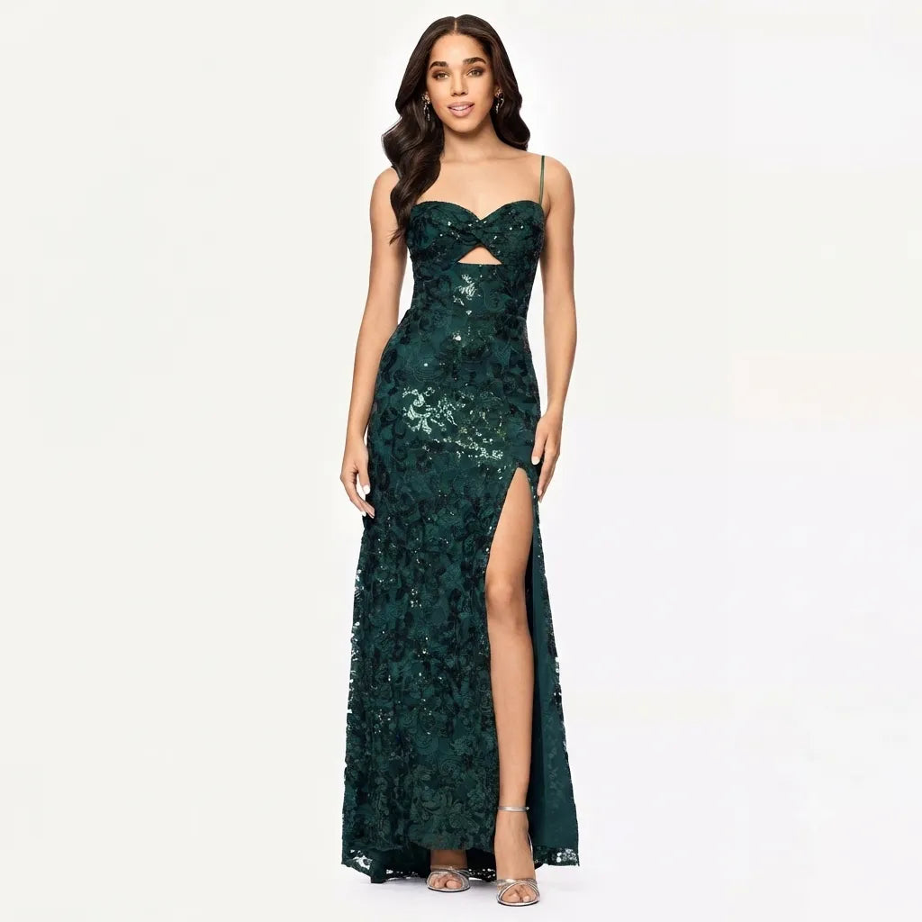 A woman modeling a floor-length dark green sequined gown with thin straps, a sweetheart neckline, a small front cutout, and a high thigh slit, photographed against a plain light background.