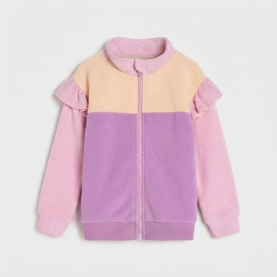 A children's colorblock fleece zip-up jacket with ruffle details on the shoulders and sleeves, featuring a pastel color scheme of pink, lavender, and pale yellow on a light gray background.
