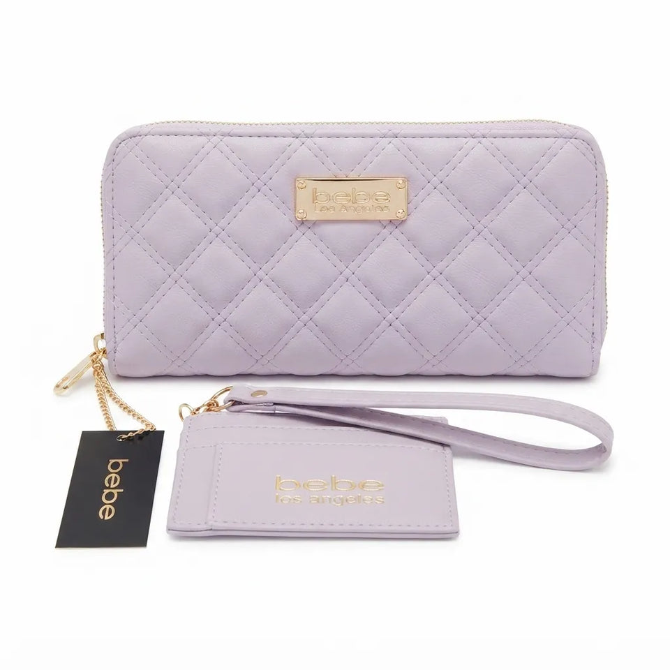 A light lavender quilted zip-around wallet with a gold-tone logo plaque, shown with a matching wristlet strap and a black hanging Bebe brand tag on a white background.