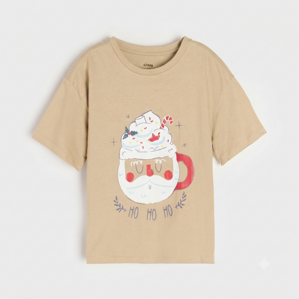 A beige short-sleeve t-shirt with a festive graphic of a Santa Claus mug topped with whipped cream and a candy cane, with 'HO HO HO' written below, shown on a light gray background.