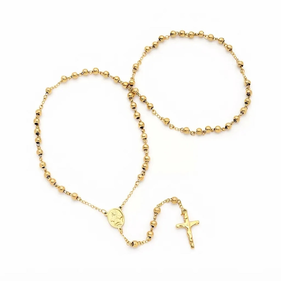 A gold beaded rosary necklace with a small round medallion and a crucifix pendant, arranged on a plain white background.