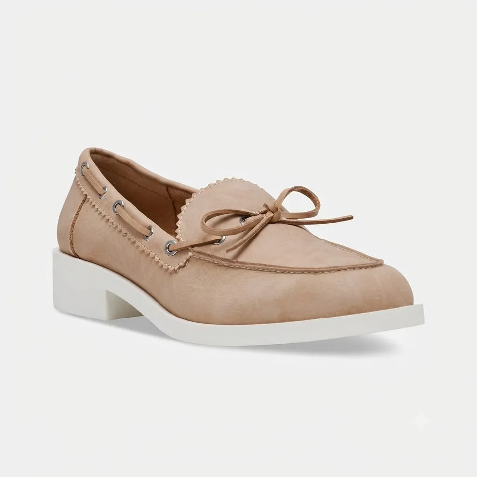 A single women's boat shoe in light tan suede with a white block heel and white sole, shown from a three-quarters angle on a light gray background.