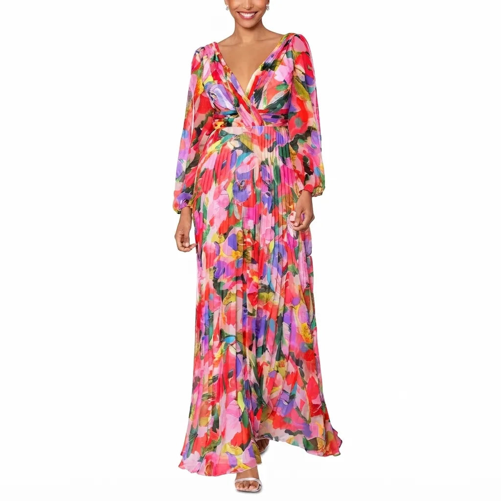 A woman wearing a long-sleeve, wrap-style maxi dress with a vibrant multicolor floral print in pink, red, orange, yellow, green, and blue, set against a plain white background.
