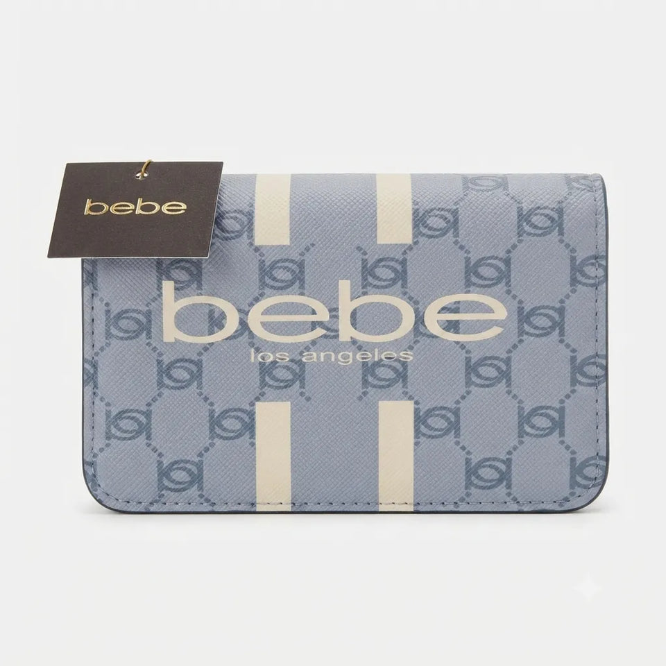 A Bebe Los Angeles wallet in a dusty blue textured canvas with a repeating monogram pattern, featuring vertical cream stripes and cream lettering, with a dark brown Bebe brand tag attached.