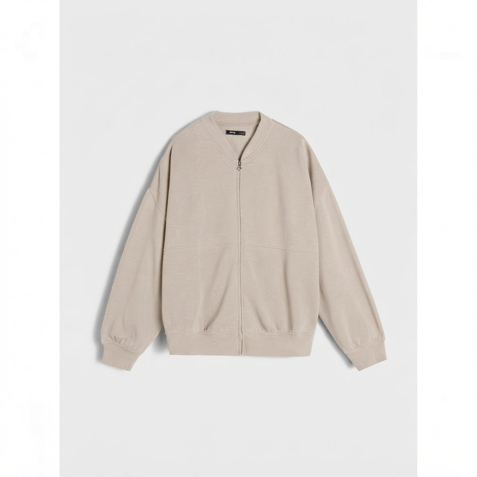 A light beige zip-up jacket with a relaxed fit, laid flat against a light gray background.