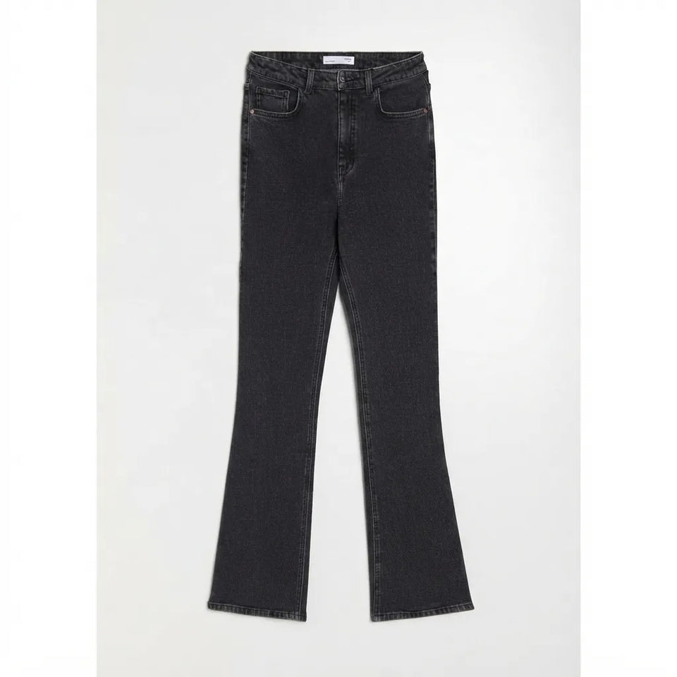 A pair of dark gray flared jeans laid flat against a light gray background.
