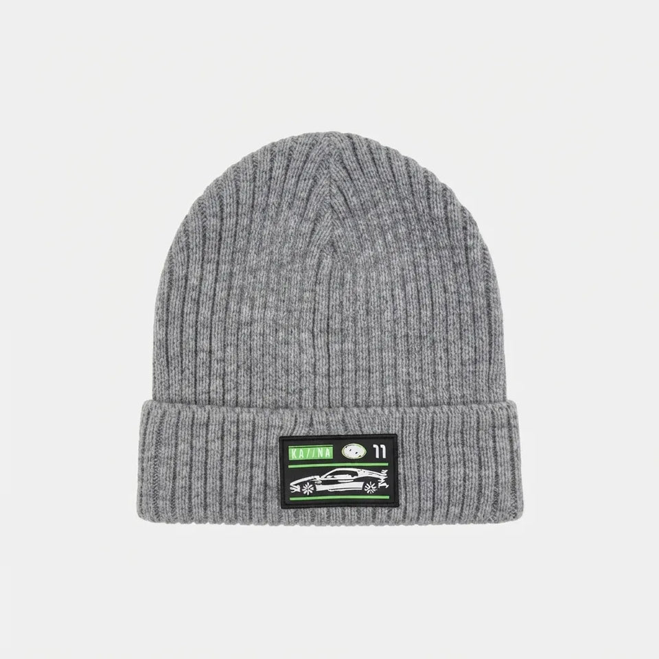 A heather gray ribbed knit beanie hat with a folded cuff, featuring a black rectangular patch on the front with a green and white graphic.