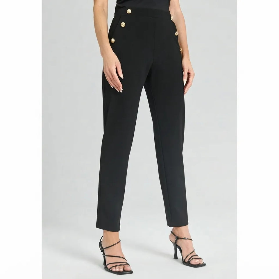 A model wearing black cropped trousers with gold button details on the sides, paired with black strappy high-heeled sandals, shown against a light gray studio background.
