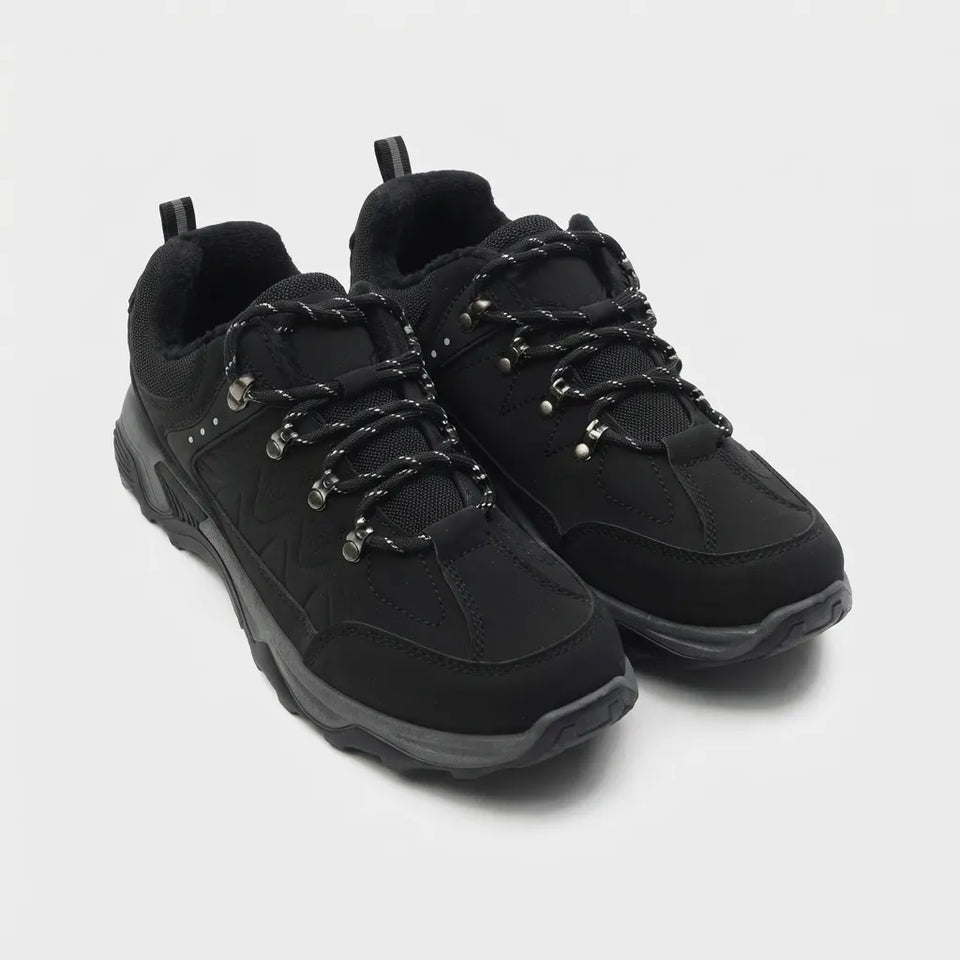 A pair of black low-top lace-up shoes with textured laces, silver eyelets, and thick black soles, photographed on a light gray background.