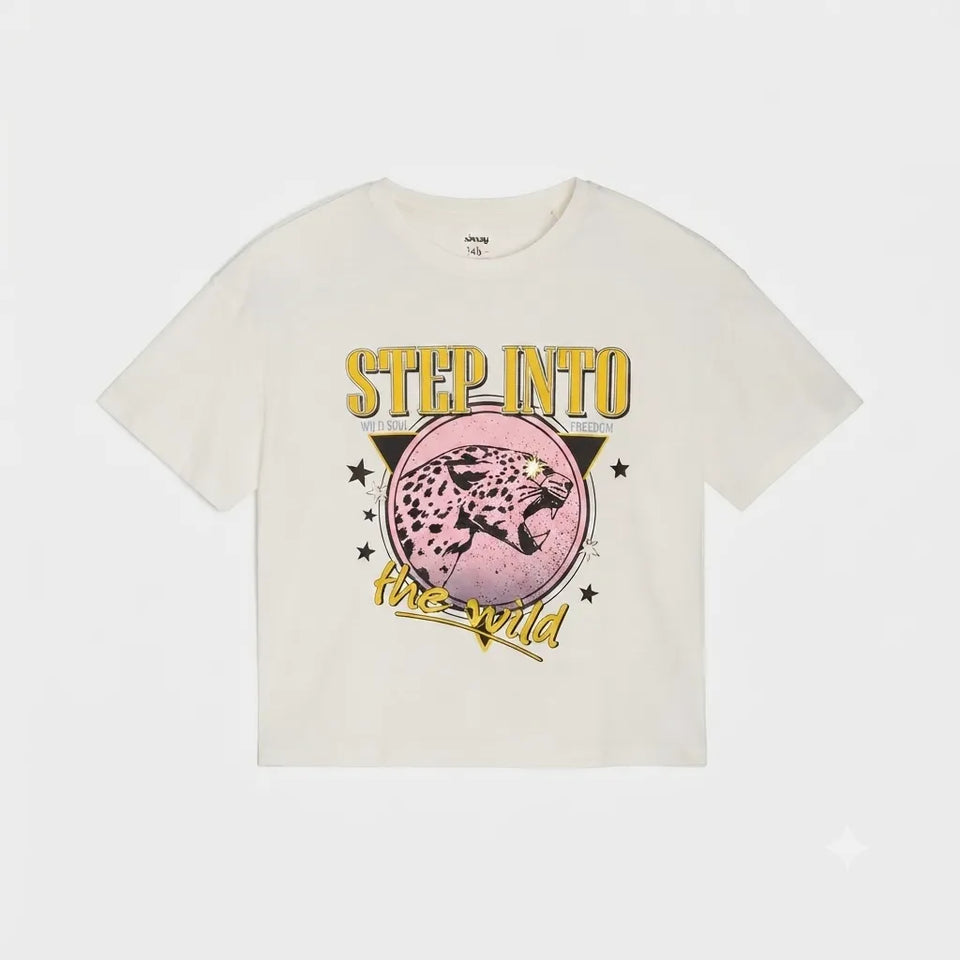 An off-white cropped t-shirt featuring a graphic print of a leopard inside a pink circle with the text 'STEP INTO the Wild' in yellow, displayed on a light gray background.