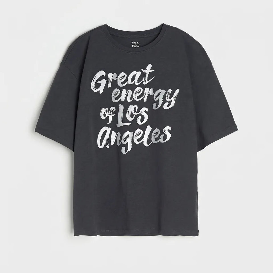 A dark charcoal gray short-sleeve t-shirt with 'Great energy of Los Angeles' printed in a white brush script across the front, displayed against a light gray background.
