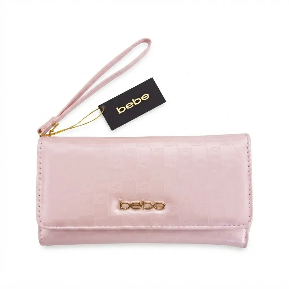 A light pink Bebe wallet with a wristlet strap, gold-tone logo hardware, and a black brand tag, shown on a plain white background.