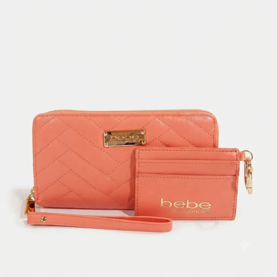 A coral pink quilted wallet set by Bebe The Beauty Box, featuring a large zip-around wallet with a wristlet strap and a smaller card holder with gold-tone hardware and logo.