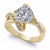 A yellow gold split-shank engagement ring featuring a large round brilliant-cut center stone and smaller accent stones along the shoulders, set against a clean white background.