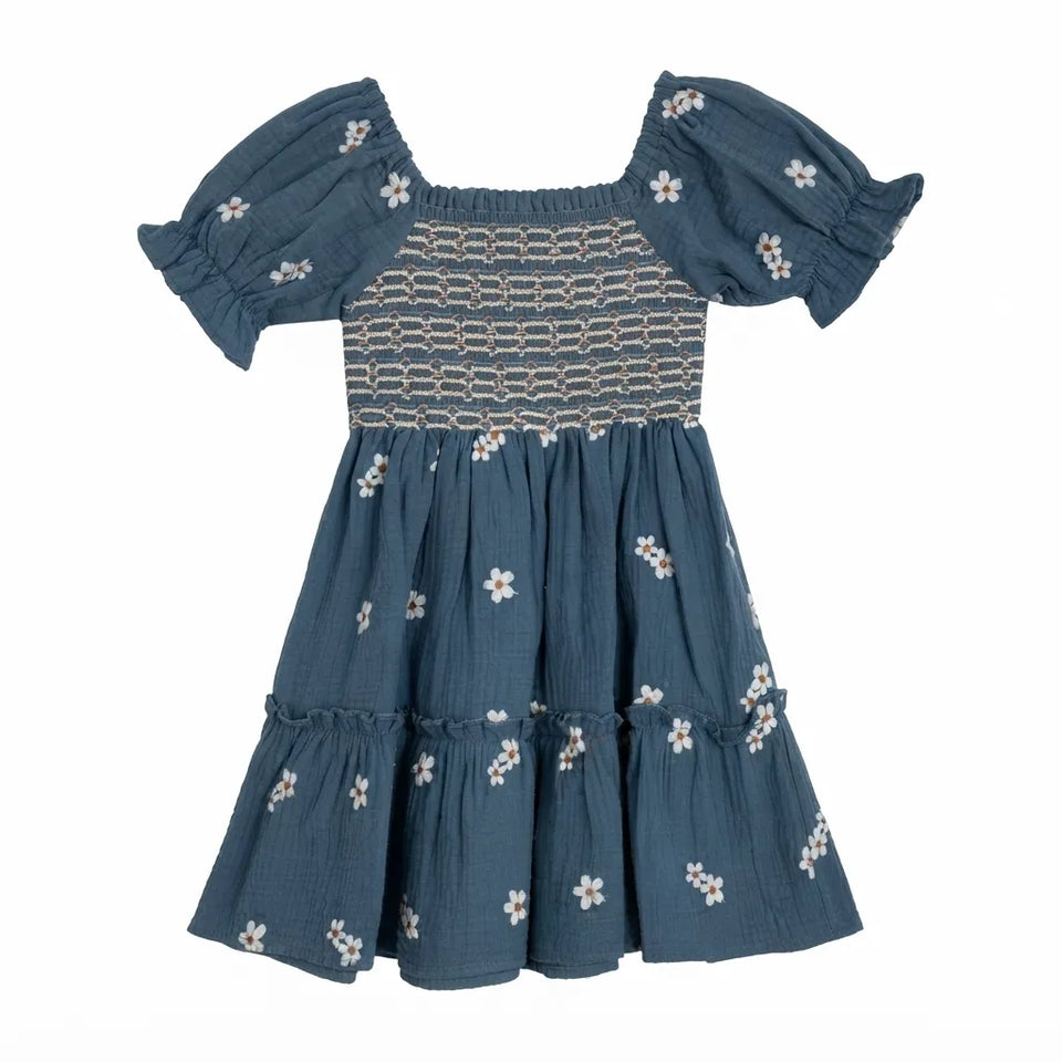 A toddler's blue smocked dress with puff sleeves and white floral embroidery, shown against a plain white background.