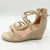A pair of women's wedge sandals in beige suede with crisscross ankle straps, a buckle closure, and a braided jute-wrapped wedge heel, shown on a light gray background.