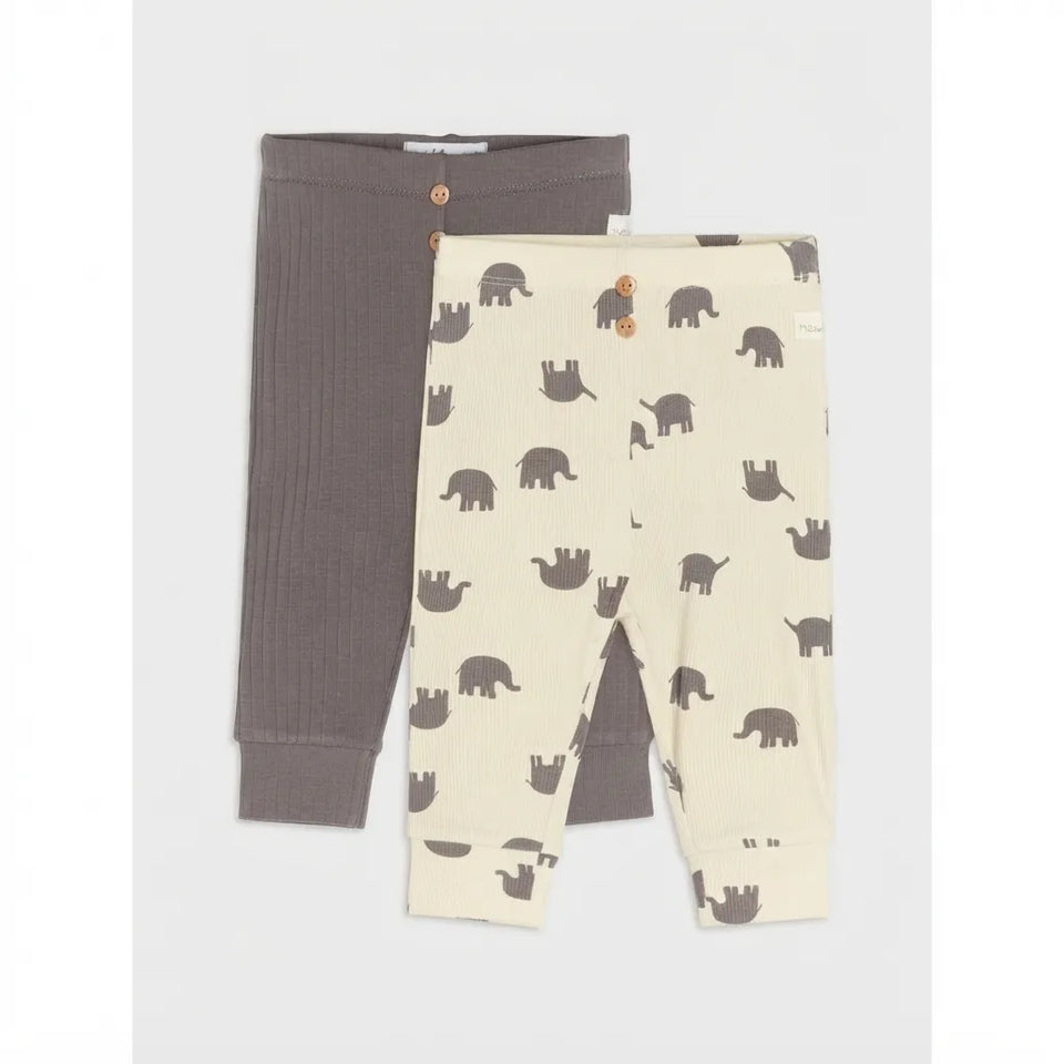 Two pairs of baby leggings laid flat on a light gray background. The back pair is solid dark taupe-brown with a button waist, and the front pair is cream with an all-over dark gray elephant print and button waist.